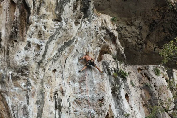 年轻人爬上岩石 — 图库照片