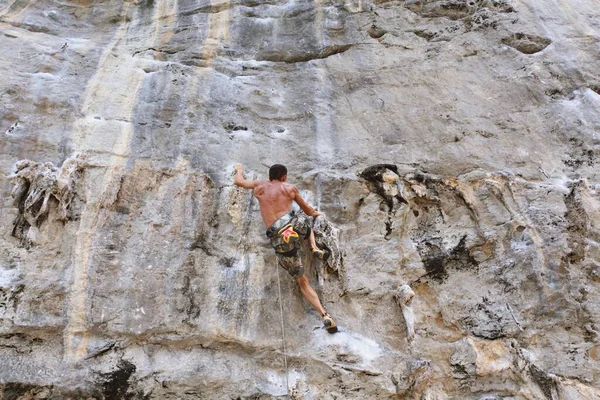 若い男が岩の上に登り — ストック写真