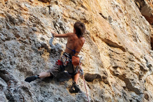 年轻女子爬上岩石 — 图库照片