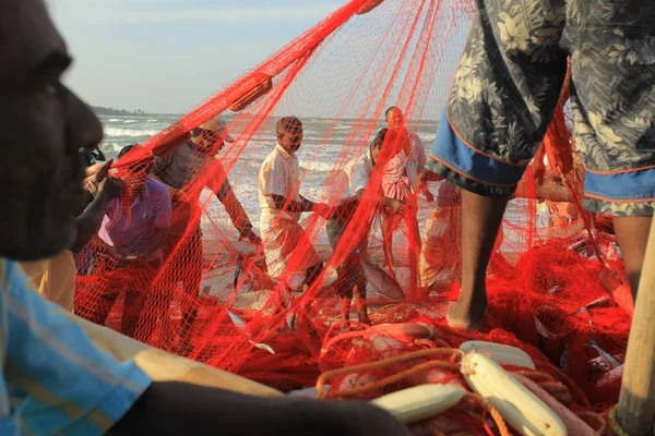 在印度海滩上有渔船的渔民 图库图片