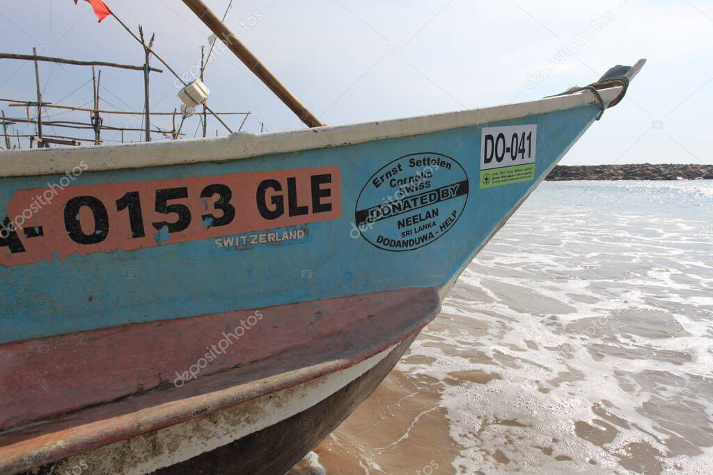  old wooden fishing boats on beach in india 