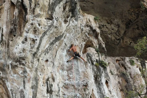 年轻人爬上岩石 — 图库照片