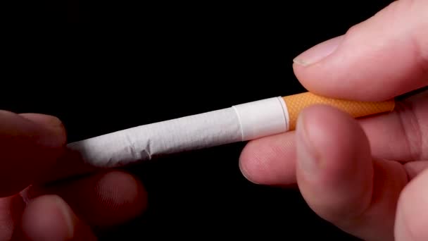 Gros plan blanc mâle main casse une cigarette en deux, cesser de fumer concept. — Video