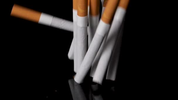 Στοίβα τσιγάρων που πέφτουν και αναπηδούν σε μαύρο φόντο σε αργή κίνηση. — Αρχείο Βίντεο