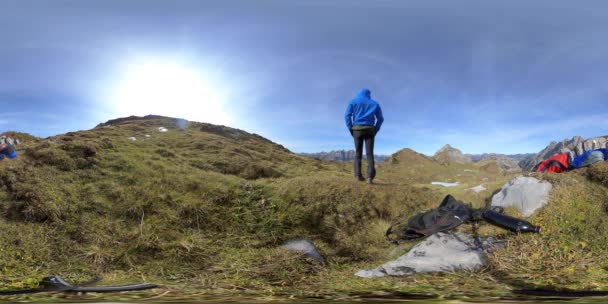 360 VR, deux jeunes hommes reposant sur une montagne froide et venteuse en Suisse. — Video