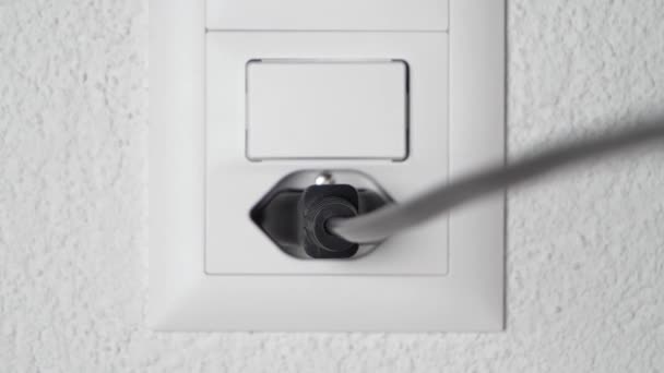 Close-up shot loskoppelen van een zwarte kabel met kracht van een moderne stopcontact. — Stockvideo