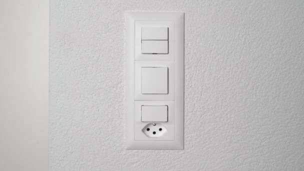 Joven adulto presionando interruptor de luz blanca en edificio moderno. — Vídeo de stock