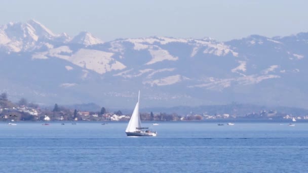 Static shot of a sailboat on the lake of Zurich, big mountains in Switzerland. — Stock Video