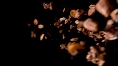 Crunchy cornflakes falling into dark background on the right side.