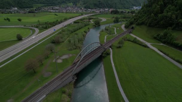 Vzdušný zpětný náklon nahoru, aby bylo vidět údolí s dálnicí a vysílaným stěžněm. — Stock video