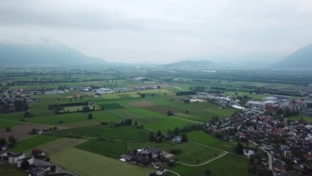 Letecká panenka vpřed nad vesnicí a zelenou zemědělskou půdou, Švýcarsko — Stock video