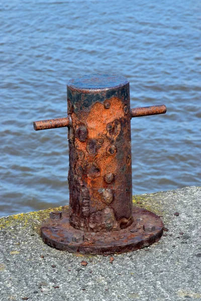 Старый ржавый боллард не использовался сейчас, но использовался, чтобы связать корабли в прошлом . — стоковое фото