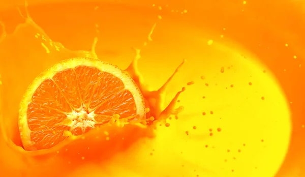 Orange juice splash with orange fruit cut in half. Background with copy space.