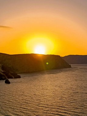 Güneşin doğuşu deniz kıyısında ve dağın yamacında