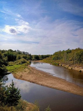 Rus ormanlarının ortasındaki orman nehrinin mavi gökyüzünün altındaki doğa ve renkli manzarası.