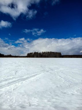 Güneşli mavi gökyüzünün altındaki vadide beyaz kış karı