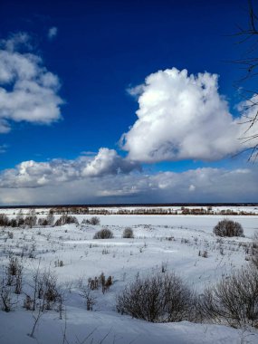 Güneşli mavi gökyüzünün altındaki vadide beyaz kış karı