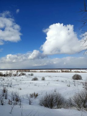 Güneşli mavi gökyüzünün altındaki vadide beyaz kış karı