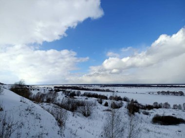 Güneşli mavi gökyüzünün altındaki vadide beyaz kış karı