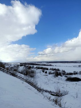 Güneşli mavi gökyüzünün altındaki vadide beyaz kış karı
