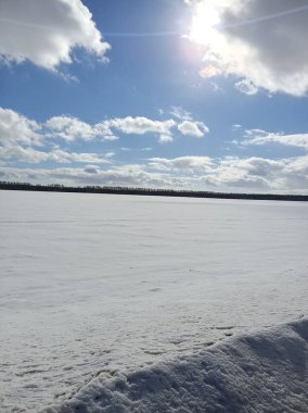 Güneşli mavi gökyüzünün altındaki vadide beyaz kış karı