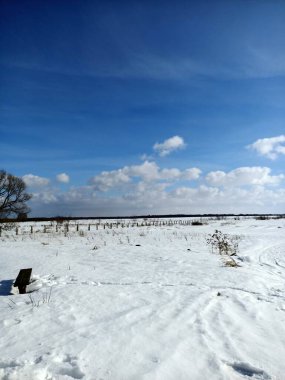 Nehrin buzunun üzerindeki beyaz kar tarlası Mavi gökyüzünün altında bulutlarla