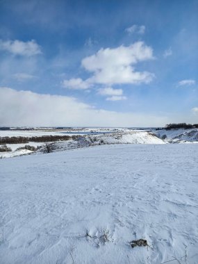 Nehrin buzunun üzerindeki beyaz kar tarlası Mavi gökyüzünün altında bulutlarla