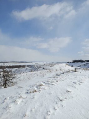 Nehrin buzunun üzerindeki beyaz kar tarlası Mavi gökyüzünün altında bulutlarla