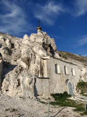 Rus çayırlarındaki tebeşir mağaralarında kutsal Ortodoks kiliseleri ve manastırı, mavi gökyüzünün altında tebeşir ve kayalar var.