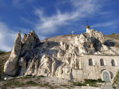 Rus çayırlarındaki tebeşir mağaralarında kutsal Ortodoks kiliseleri ve manastırı, mavi gökyüzünün altında tebeşir ve kayalar var.