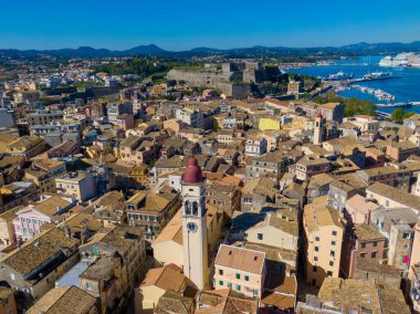 Yunanistan 'ın tarihi Korfu kasabasının hava manzarası. İkonik Aziz Spyridon Kilisesi, arka planda hareketli bir liman ve Eski Kale ile pitoresk şehir manzarasında dimdik ayakta duruyor.