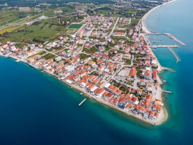 Mytikas, Yunanistan: Kırmızı çatılı evler, sakin bir liman ve çarpıcı turkuaz İyon Denizi suyuna sahip yarımadadaki pitoresk bir kıyı köyünün hava manzarası.