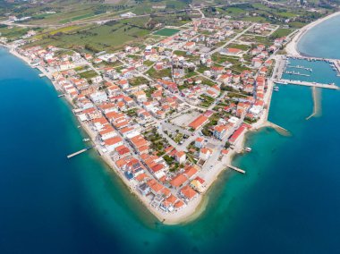 İyon Denizi 'nde bir yarımadadaki sakin bir Yunan köyü olan Mytikas' ın havadan görünüşü, kırmızı çatılı evler, liman, dağlar ve turkuaz su ile çevrili..