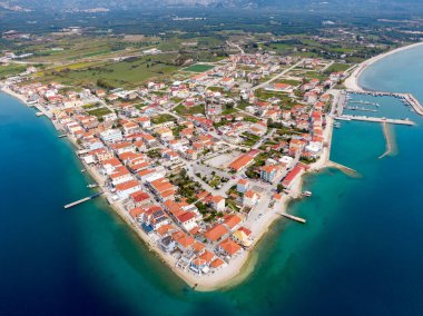 İyon Denizi 'nde bir yarımadadaki sakin bir Yunan köyü olan Mytikas' ın havadan görünüşü, kırmızı çatılı evler, liman, dağlar ve turkuaz su ile çevrili..