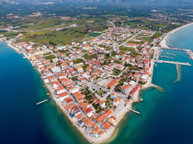 İyon Denizi 'nde bir yarımadadaki sakin bir Yunan köyü olan Mytikas' ın havadan görünüşü, kırmızı çatılı evler, liman, dağlar ve turkuaz su ile çevrili..