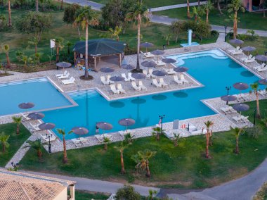 Lüks Havacılık Merkezi: Turkuaz havuzlu, palmiye ağaçlı ve yemyeşil bahçeli sakin bir kaçış, çok özel bir yaz tatili için mükemmel.