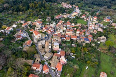 Pagi köyü Korfu Yunanistan 'daki yoğun dolu geleneksel evlerin tepeden aşağı hava manzaralı kırmızı kiremitli çatıları ve dar sokak insansız hava aracı görüntüsü