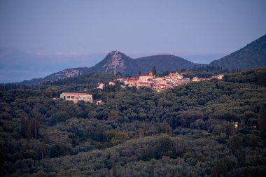 Yunanistan 'ın kuzey Korfu kentindeki geleneksel dağ köyü Nimfes' in alacakaranlık manzarası, yoğun yeşil zeytin korulukları arasında yer alıyor..