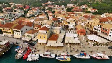 Gaios, Paxos Adası, Yunanistan 'ın Vibrant Rıhtımı, Terracotta Çatıları, Bustling Cafeler, Demirlemiş Tekneler ve Yaz Atmosferinin Tadını Çıkaran Turistlerin Tepe Aşağı Hava Manzarası