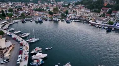Korfu 'daki Kassiopi limanında sinemanın insansız hava aracı uçuşu Yunanistan' ın temiz mavi sulara yanaşan kalabalık sahil yolu, dükkan ve tekneleri ele geçiriyor.