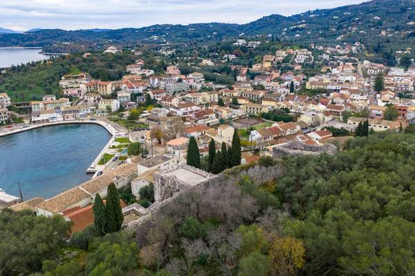 Kassiopi limanının panoramik hava aracı görüntüleri ve Korfu Yunanistan 'daki şato harabeleri, tekneli manzaralı kıyı köyü