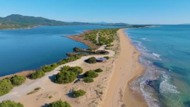 Yüksek irtifa drone görüntüsü Halikounas sahilinin eşsiz kumlu sahili ve sedir ormanı kumulları Korfu 'daki sulak alanları İyon denizinden ayırıyor.