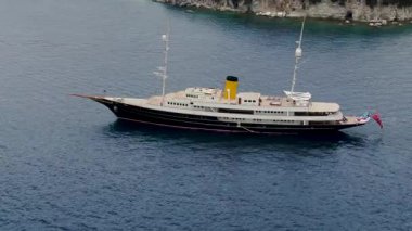 Koyu Mavi Deniz Kıyısı Kayalıkları Yanındaki Klasik Kara ve Krem Lüks Süper Yatın Hava Görüntüsü