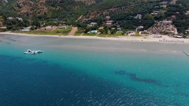 Kuzey Korfu Yunanistan 'da turkuaz deniz yeşil tepeleri ve yaz tatillerinde İyon Adaları' nda turizm ve seyahat konseptiyle kumlu bir sahil manzarası