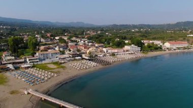 Korfu 'daki kumlu Roda Sahili' ne çarpan turkuaz dalgaların yukarıdan görünüşü kristal berrak su ve kıyı şeridi dokularını doğa ve rahatlama için ideal olarak yakalıyor