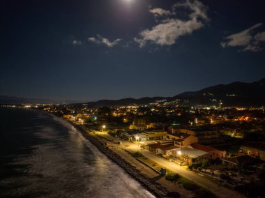 Korfu 'daki Acharavi Sahil Kasabası' nın Hava Gecesi Manzarası Dolunay ve Long Beach üzerindeki Bulutlar, Aydınlanmış Sahil Resort ve Köy Işıkları