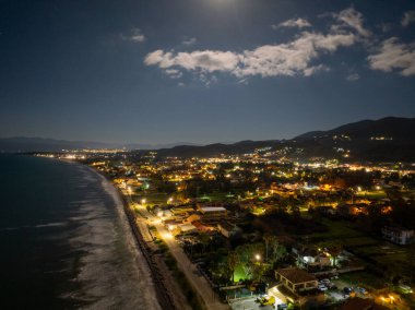 Korfu 'daki Acharavi Sahil Kasabası' nın Hava Gecesi Manzarası Dolunay ve Long Beach üzerindeki Bulutlar, Aydınlanmış Sahil Resort ve Köy Işıkları