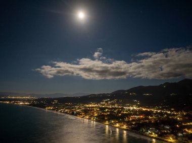 Korfu 'daki Acharavi Sahil Kasabası' nın Hava Gecesi Manzarası Dolunay ve Long Beach üzerindeki Bulutlar, Aydınlanmış Sahil Resort ve Köy Işıkları