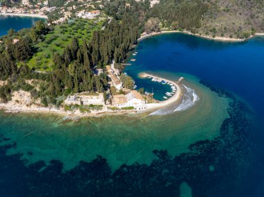 Korfu 'daki Kouloura Kıyı Şeridi' nin Geniş Hava Panoramik Manzarası Yunanistan 'da Yemyeşil Kıbrıs Ağaçları Turkuaz Koyu ve Limandaki Tekneleri Gösteriyor