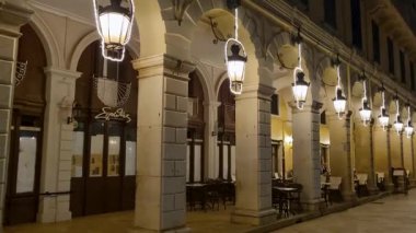 Korfu Kasabası Gece Atmosferindeki Liston Güvertesi 'ndeki kemerlerden sarkan Aydınlatılmış Vintage Fenerler Sırası